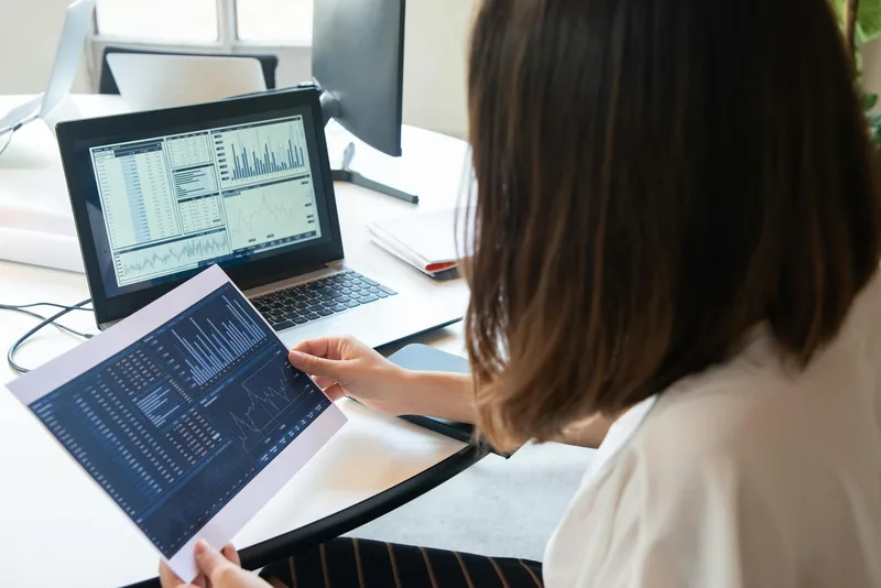 A solo creator reviewing content analytics on a laptop, representing a weekly feedback loop review session focused on business actions rather than vanity metrics