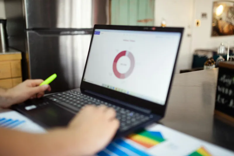 Solo creator reviewing Instagram analytics on a laptop at a clean home workspace, focused expression