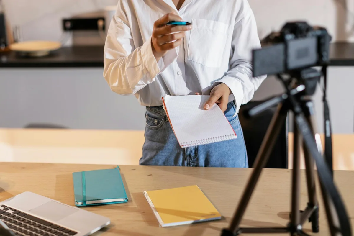 Solo creator at a desk planning Instagram content on a laptop, notes scattered nearby, focused expression