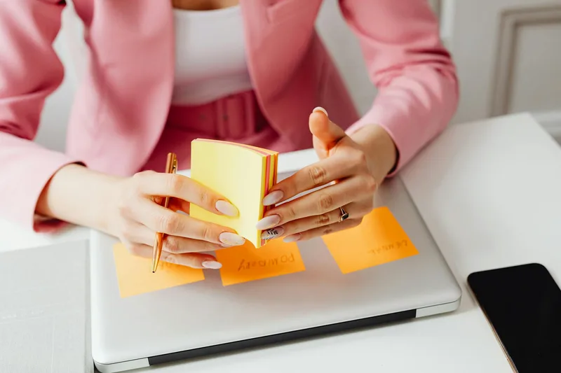 Creator at a desk with sticky notes on their monitor, reviewing a launch content plan and preparing Instagram Reels for a product release week