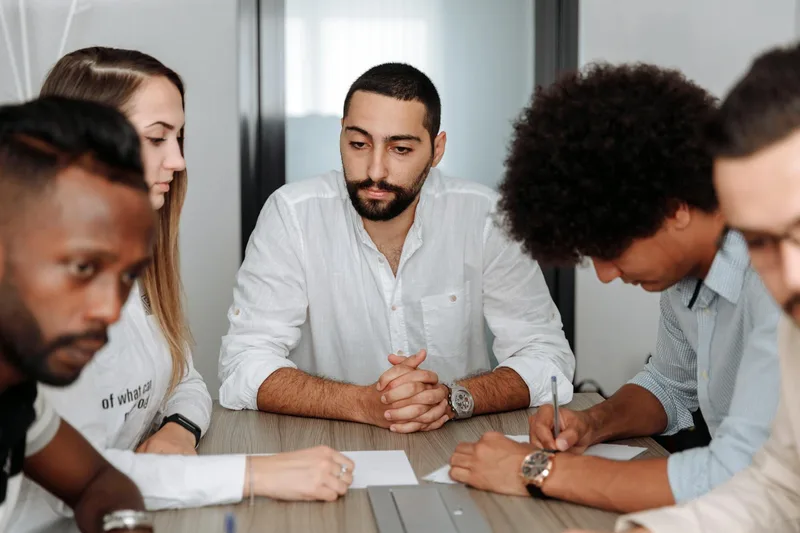 Diverse team in a collaborative meeting, representing the community-building function of LinkedIn engagement content