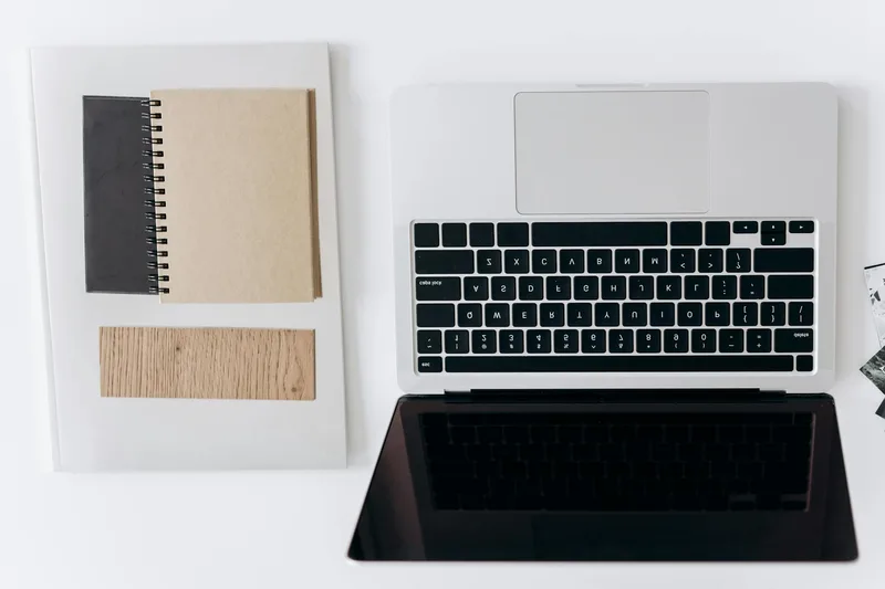 Creator reviewing an offer page on a laptop, minimal workspace with clean design visible — digital product or service page for solo creators