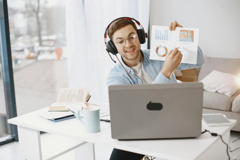 Smiling man with headphones during virtual meeting showing graphs — business TikTok content format example