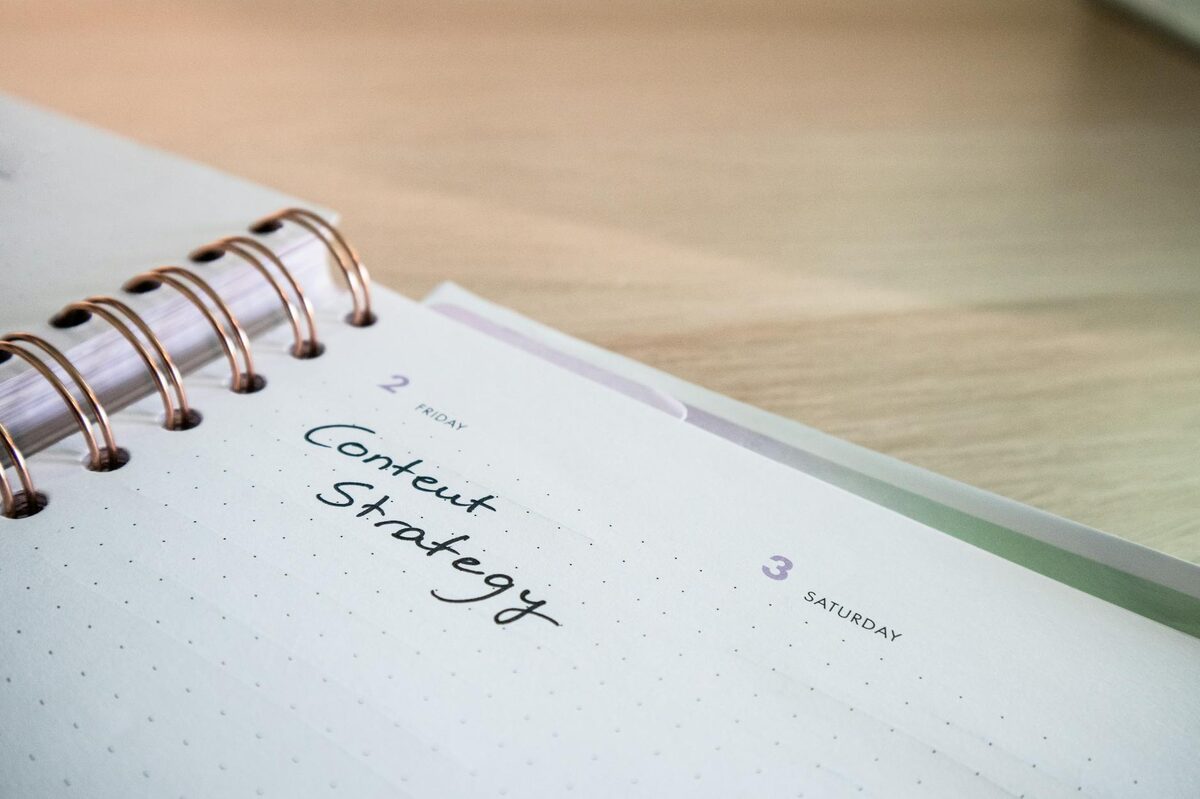 Notebook planner open to a “Content Strategy” page on a wooden desk — goal-based TikTok content strategy