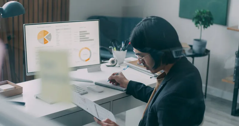 Business person reviewing analytics and charts at a modern office desk